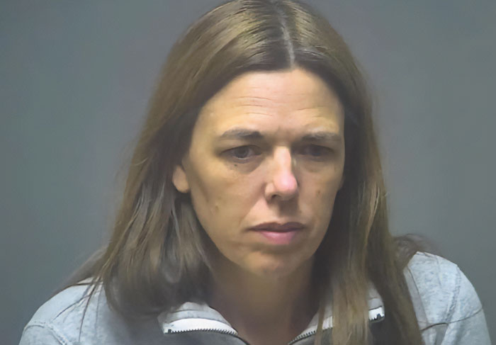 Woman with long brown hair wearing a gray jacket, looking upset before sentencing in a lewd texts case involving her daughter. Woman with long brown hair wearing a gray jacket, looking upset before sentencing in a lewd texts case involving her daughter.