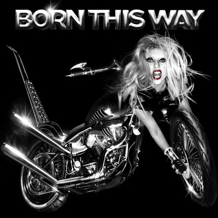 Black and white photo of a woman with wild hair posed on a shiny motorcycle, an example of bad album covers.