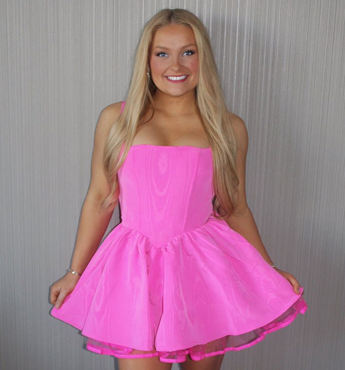 Young woman in a bright pink dress smiling at the camera, linked to cheerleader arrested news story. Young woman in a bright pink dress smiling at the camera, linked to cheerleader arrested news story.