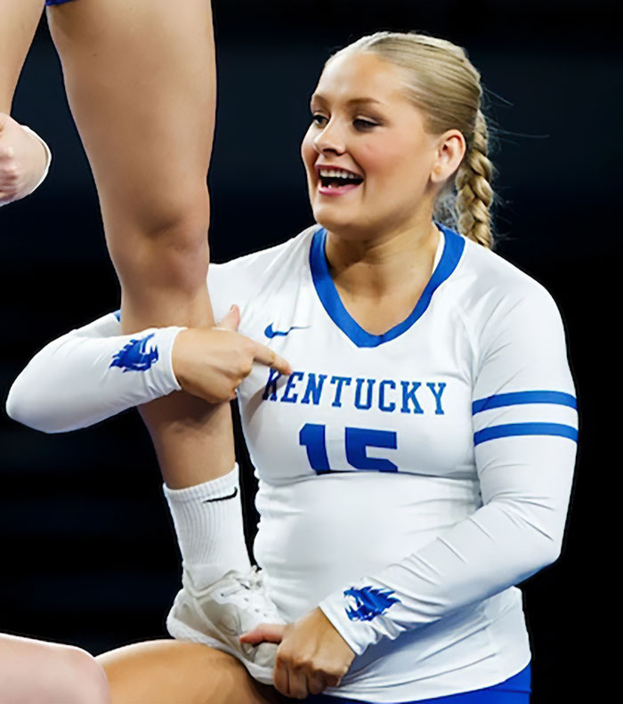 Cheerleader in Kentucky uniform performing a stunt with a focus on baby belly during an April event. Cheerleader in Kentucky uniform performing a stunt with a focus on baby belly during an April event.