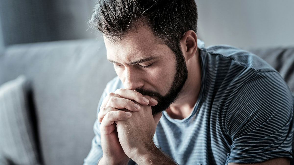 Man with beard in striped shirt looking distressed, reflecting the consequences of a crime despite being proven not guilty.