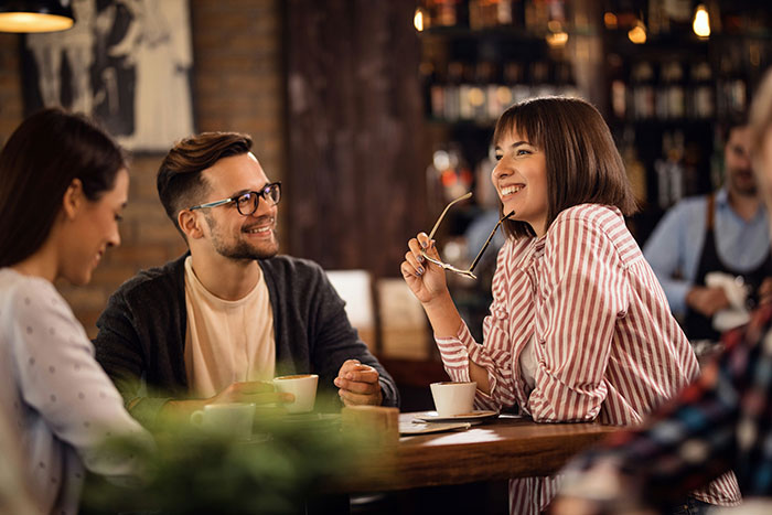 Man and woman engaging in a friendly conversation at a cafe, highlighting robotically calculated relationship choices. Man and woman engaging in a friendly conversation at a cafe, highlighting robotically calculated relationship choices.