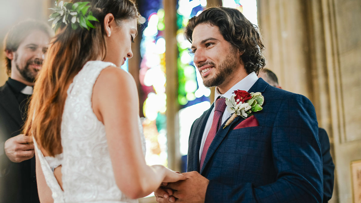 Man and woman exchanging rings in a wedding ceremony, highlighting choice with brains instead of heart in a church setting.