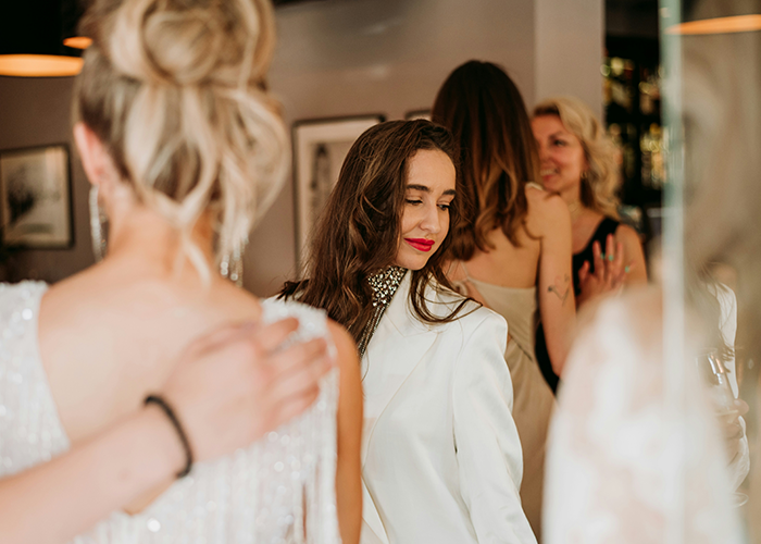 Woman pretending to be the bride at sister-in-law’s wedding while dressed elegantly, with other guests in the background. Woman pretending to be the bride at sister-in-law’s wedding while dressed elegantly, with other guests in the background.