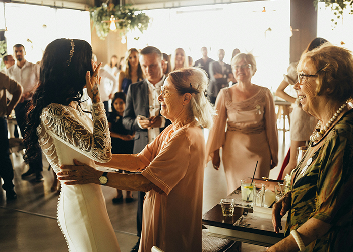 Woman in a wedding dress interacts with guests at a wedding, highlighting the bride and SIL family moment. Woman in a wedding dress interacts with guests at a wedding, highlighting the bride and SIL family moment.