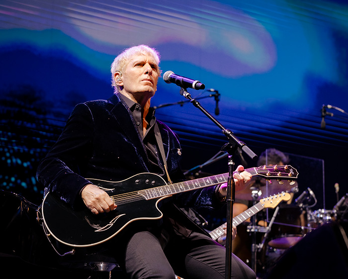 Michael Bolton performing on stage with a guitar, highlighting the weird symptom before his heartbreaking diagnosis. Michael Bolton performing on stage with a guitar, highlighting the weird symptom before his heartbreaking diagnosis.