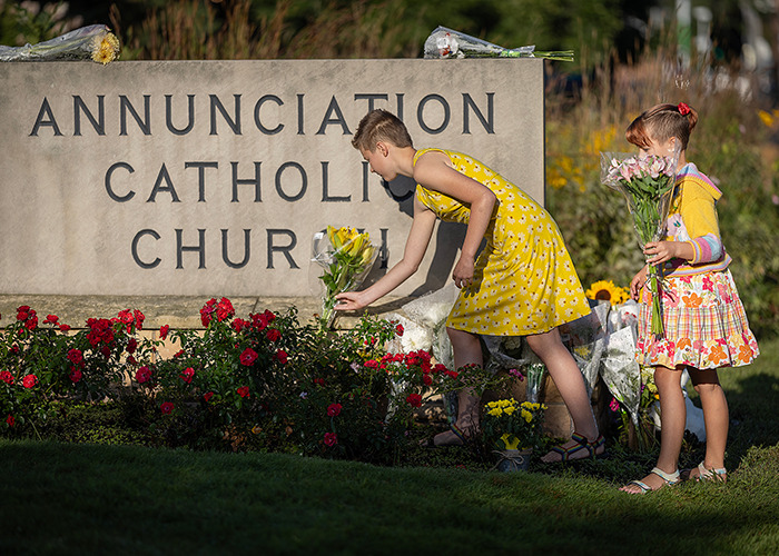Two girls placing flowers at Annunciation Catholic Church, related to Minneapolis suspect's furry girlfriend and journal entries. Two girls placing flowers at Annunciation Catholic Church, related to Minneapolis suspect's furry girlfriend and journal entries.
