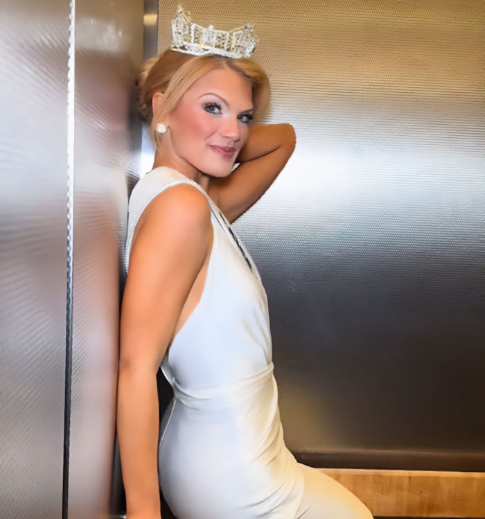 Miss America wearing a crown and white dress, posing confidently after winning amid backlash over her look. Miss America wearing a crown and white dress, posing confidently after winning amid backlash over her look.