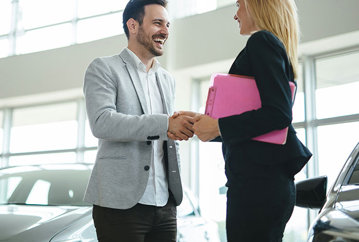 Man and woman shaking hands in a bright office setting illustrating TikTok moms discussing hated professions.
