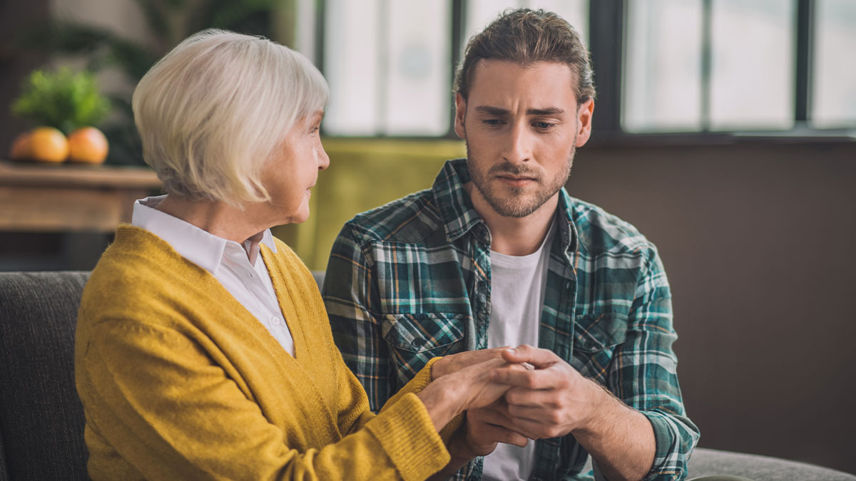 A worried young man and older woman having a serious conversation about college acceptance letters hidden by mom.