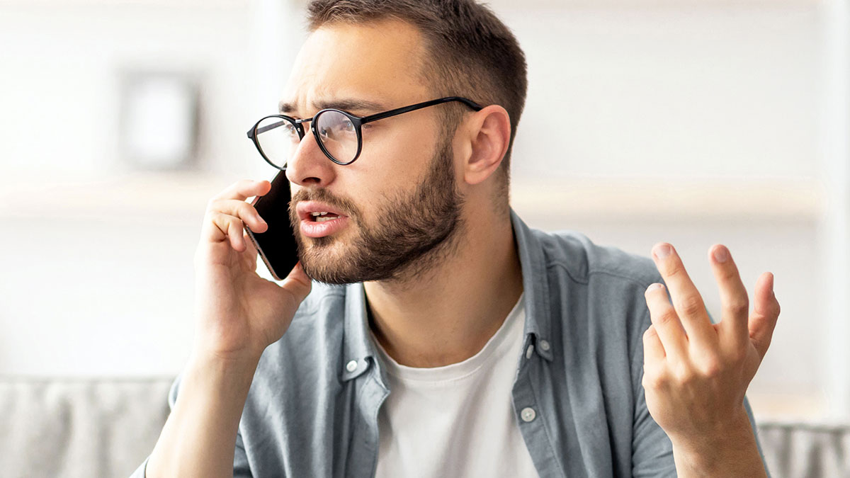 Man with glasses looking frustrated while on a phone call about babysitting and a mom gone MIA for hours