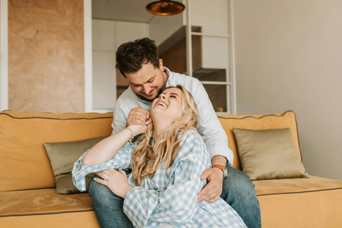 Couple sharing affectionate moment at home, illustrating themes of pregnancy and family support expectations. Couple sharing affectionate moment at home, illustrating themes of pregnancy and family support expectations.