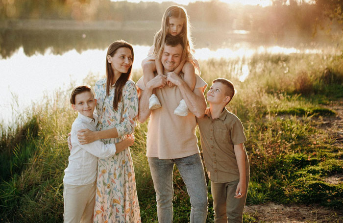 Family outdoors by the lake with children, representing adult kids expected to help with a new pregnancy at 46 years old. Family outdoors by the lake with children, representing adult kids expected to help with a new pregnancy at 46 years old.