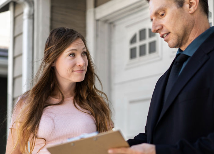Neighbor upset speaks with nanny holding clipboard near front home, discussing parking issues and concerns outside. Neighbor upset speaks with nanny holding clipboard near front home, discussing parking issues and concerns outside.