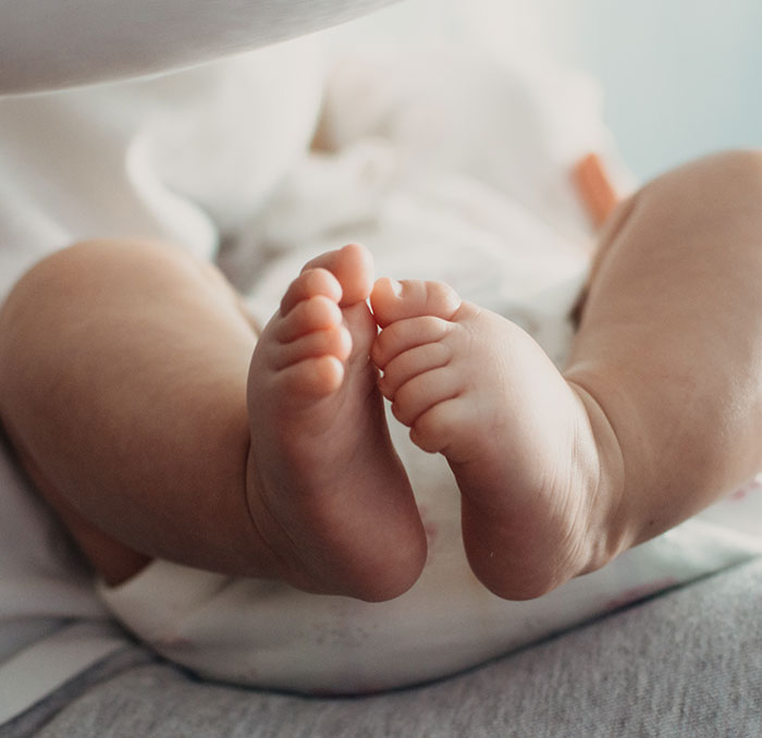 Close-up of newborn feet lying on a soft surface, illustrating tragic cheerleader arrested case involving a hidden baby. Close-up of newborn feet lying on a soft surface, illustrating tragic cheerleader arrested case involving a hidden baby.