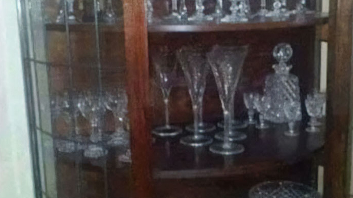 Crystal glassware collection in a wooden cabinet reflecting culture only people raised in Eastern Europe comprehend