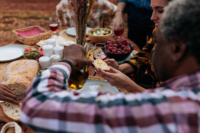 People enjoying a meal outdoors with bread and wine, highlighting food that increases dementia risk, scientists warn. People enjoying a meal outdoors with bread and wine, highlighting food that increases dementia risk, scientists warn.