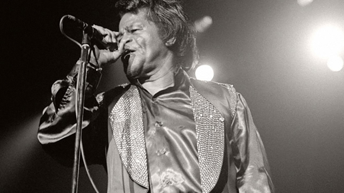 Black and white photo of a male singer performing on stage, capturing a live concert experience and music energy.