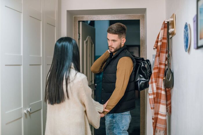 A man with a backpack and a woman holding hands in a hallway illustrating things women are not allowed to do that men can do freely.