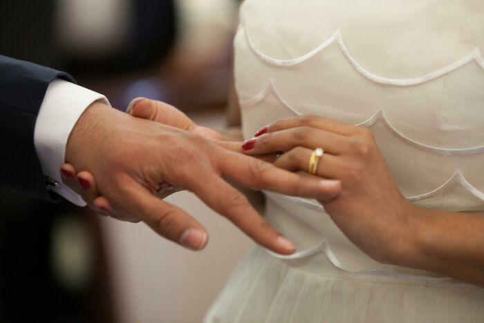 Close-up of a couple exchanging wedding rings, illustrating men who married out of pressure and their life updates.