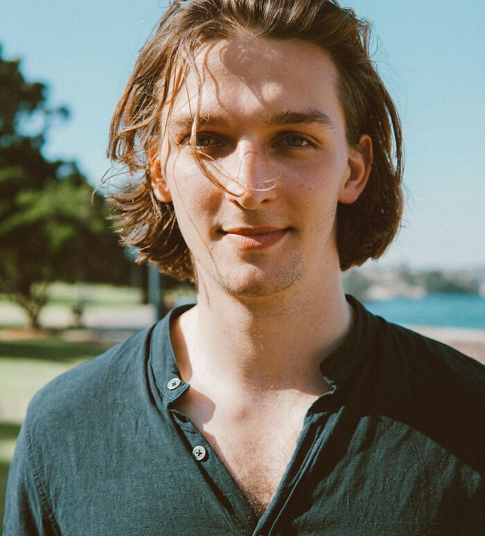 Young man outdoors with sunlight on his face, symbolizing subtle ways misogyny creeps into daily lives.