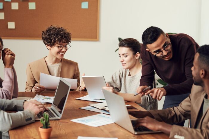 A diverse group of young professionals collaborating in an office, illustrating things women are not allowed to do freely.