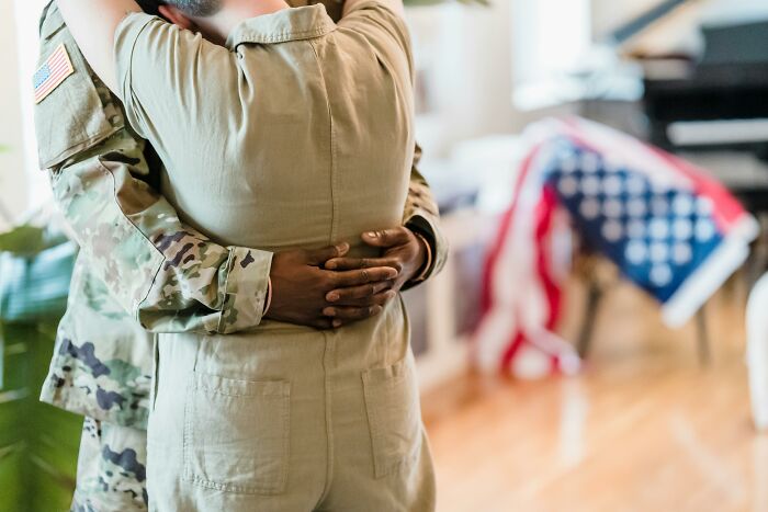 Two men in military uniforms embracing indoors, illustrating men who married out of pressure with life updates.