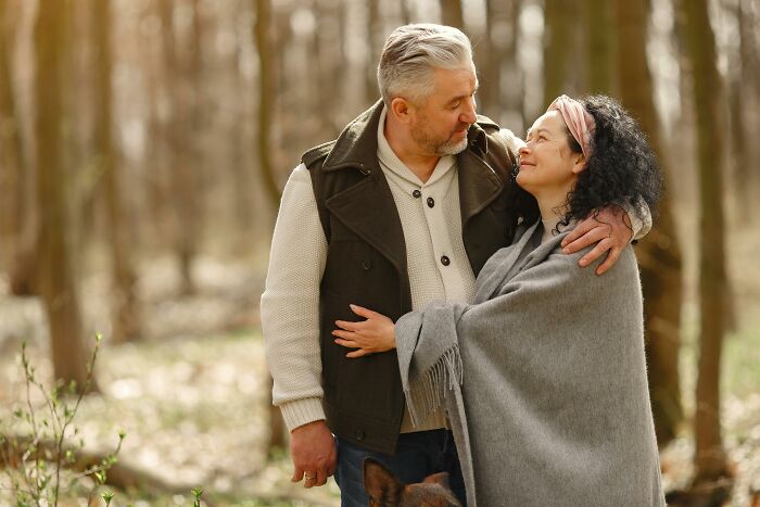 Middle-aged couple in a forest embracing each other, illustrating men who married out of pressure life updates.