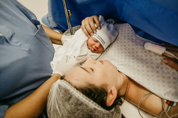 Newborn baby held by mother in hospital delivery room, symbolizing shocking family secrets revealed by people.