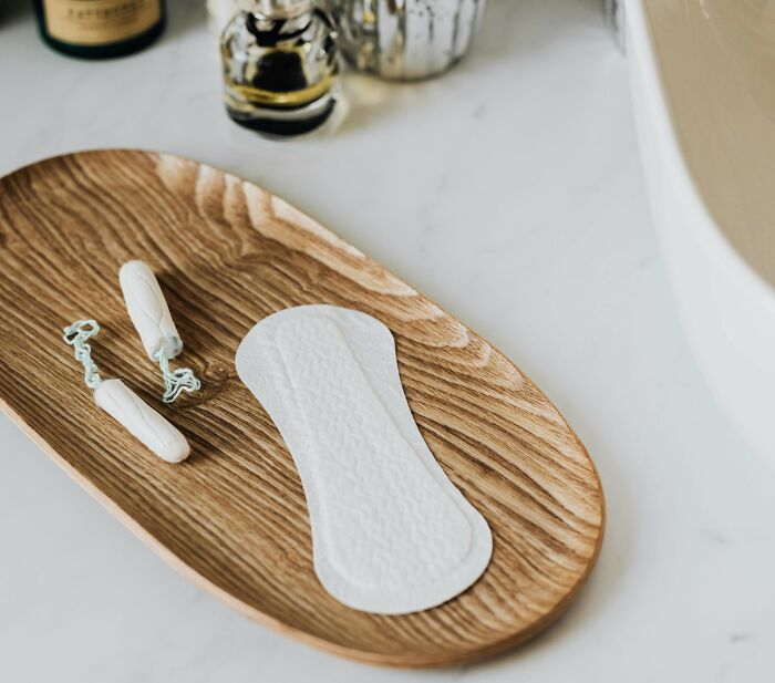 Tampons and a panty liner on a wooden tray, symbolizing intimate topics related to nasty things exes did.