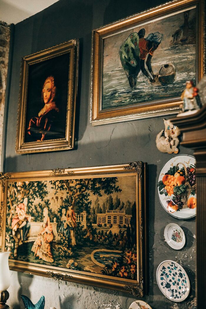 Vintage paintings and decorative plates on a dimly lit wall evoking creepy stories perfect to tell in dark woods. Vintage paintings and decorative plates on a dimly lit wall evoking creepy stories perfect to tell in dark woods.