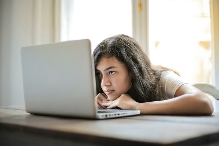 Young woman focused on laptop screen, trying to match idioms with their real definition in an online quiz challenge. Young woman focused on laptop screen, trying to match idioms with their real definition in an online quiz challenge.