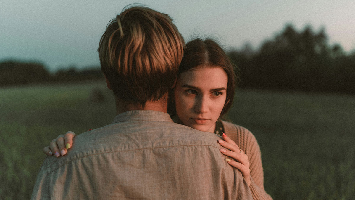 Young woman looking distant while hugging someone, expressing emotions that make people lose respect for someone.