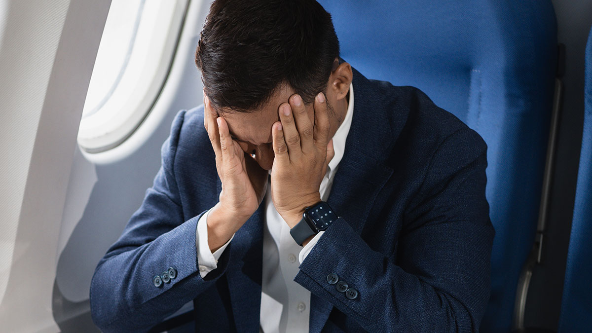 Passenger struggling with discomfort during a nightmare flight after seatmate soils himself before takeoff.