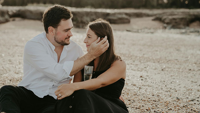 Couple sitting on the beach, sharing an intimate moment as husband explores poly lifestyle and open marriage. Couple sitting on the beach, sharing an intimate moment as husband explores poly lifestyle and open marriage.
