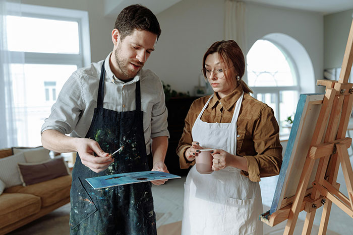 Couple exploring poly lifestyle and open marriage concepts while painting together in a bright art studio. Couple exploring poly lifestyle and open marriage concepts while painting together in a bright art studio.