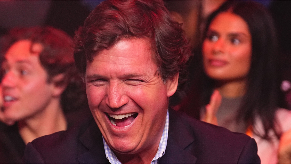 Tucker Carlson laughing in a social setting, illustrating property, marriage, and family money linked to his net worth.