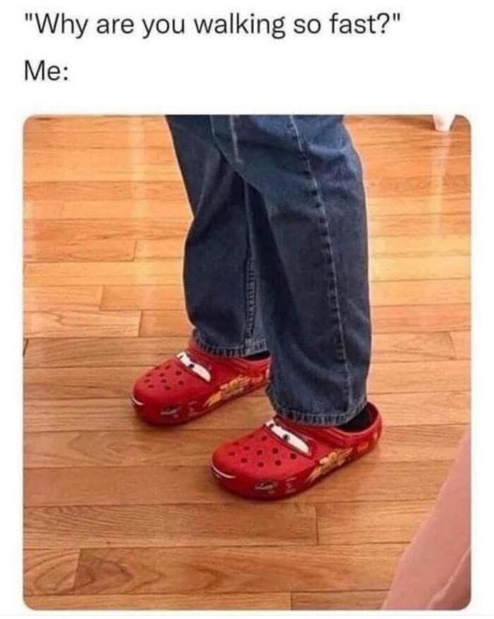 Person wearing red Cars-themed Crocs and jeans on wood floor, illustrating a viral meme about walking fast from a chaos meme page.