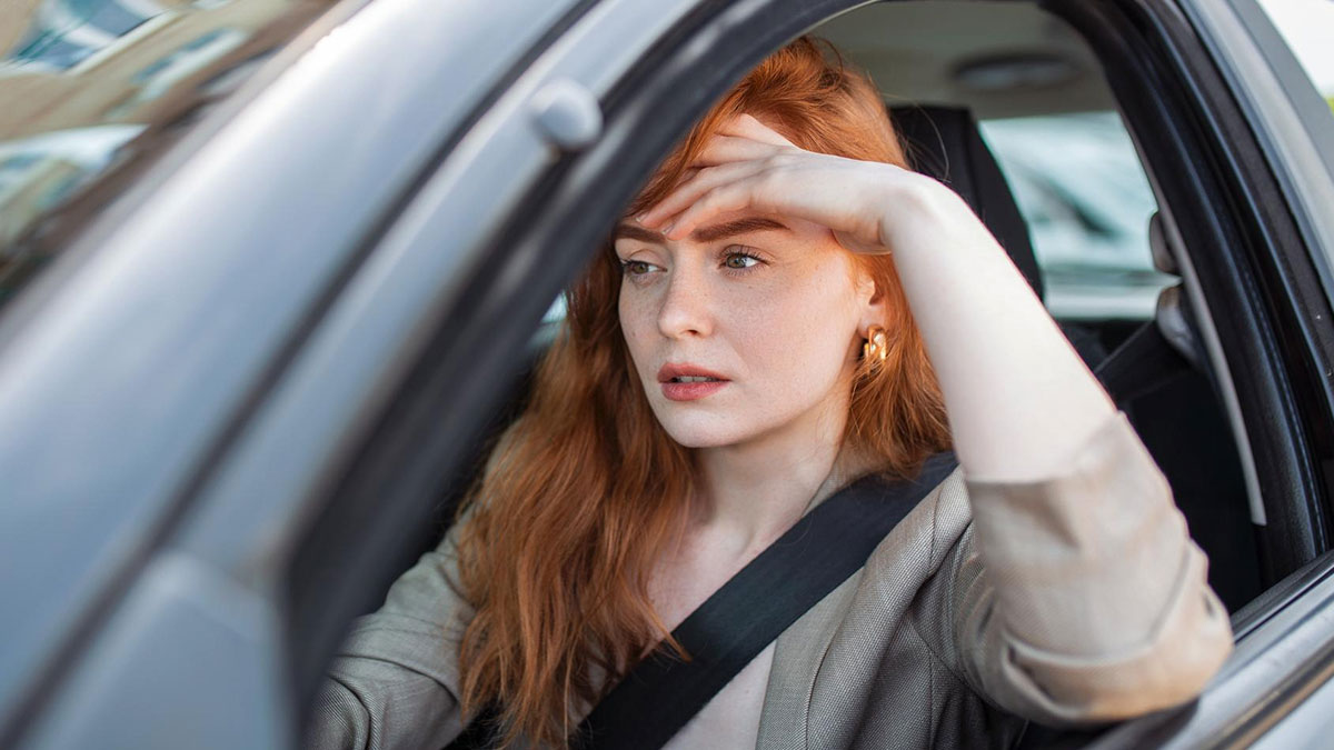 Teen girl looking concerned inside a car preparing for school drives involving a hygiene checklist for her brother.