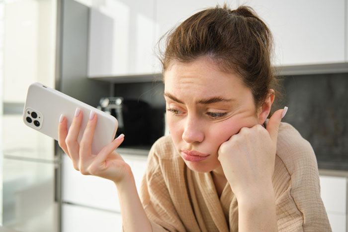 Woman showing refusal while looking at phone, reflecting refusing to watch autistic friend's show recommendation. Woman showing refusal while looking at phone, reflecting refusing to watch autistic friend's show recommendation.
