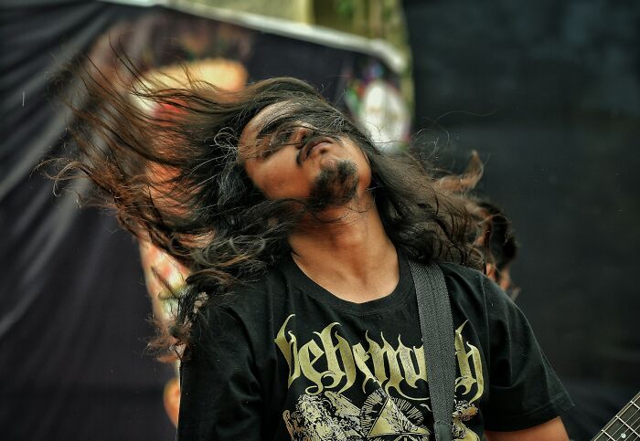 Man with long hair headbanging at a concert, representing some of the dumbest and out of touch things people have been told.
