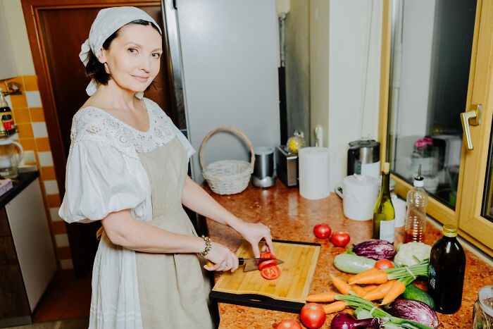 Woman preparing vegetables in kitchen, illustrating funny ways to ruin a first date with mum present.