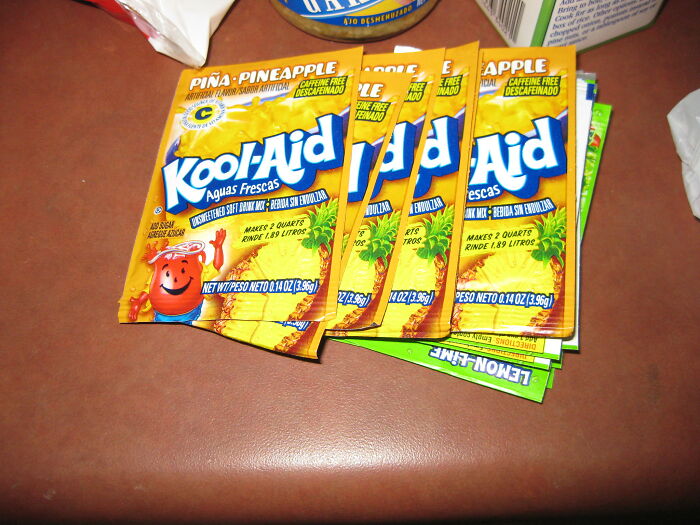 Assorted Kool-Aid drink mix packets on a table, symbolizing babysitters' horror experiences during bedtime stories.