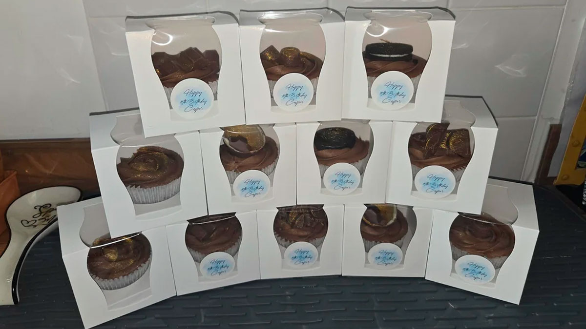 Chocolate cupcakes in white boxes stacked on a table, baked by mom for son's birthday with school reaction unexpected.