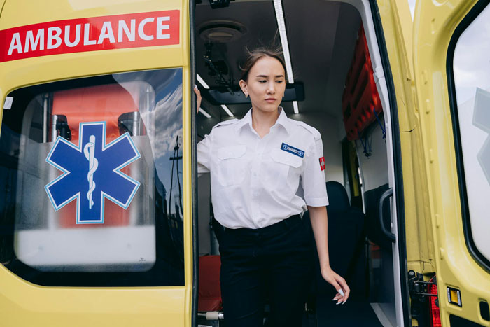 Female emergency medical responder standing at the open door of an ambulance during a Korean Airlines passenger medical crisis. Female emergency medical responder standing at the open door of an ambulance during a Korean Airlines passenger medical crisis.