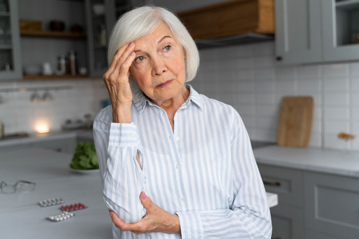 Older woman in kitchen looking thoughtful and concerned, reflecting on issues of laziness and entitlement in family care. Older woman in kitchen looking thoughtful and concerned, reflecting on issues of laziness and entitlement in family care.