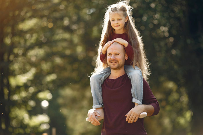 Man carrying young girl on shoulders outdoors, illustrating family dynamics and challenges with entitled disabled bro situation. Man carrying young girl on shoulders outdoors, illustrating family dynamics and challenges with entitled disabled bro situation.