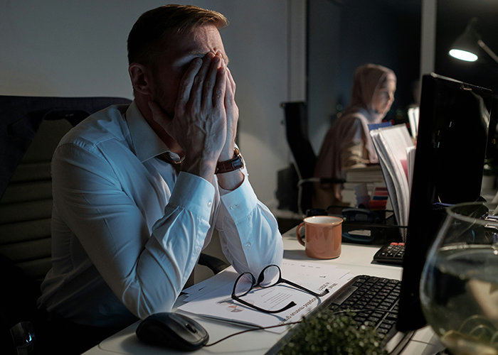 Man in office with hands on face, stressed over server down during business hours, showing signs of malicious compliance. Man in office with hands on face, stressed over server down during business hours, showing signs of malicious compliance.