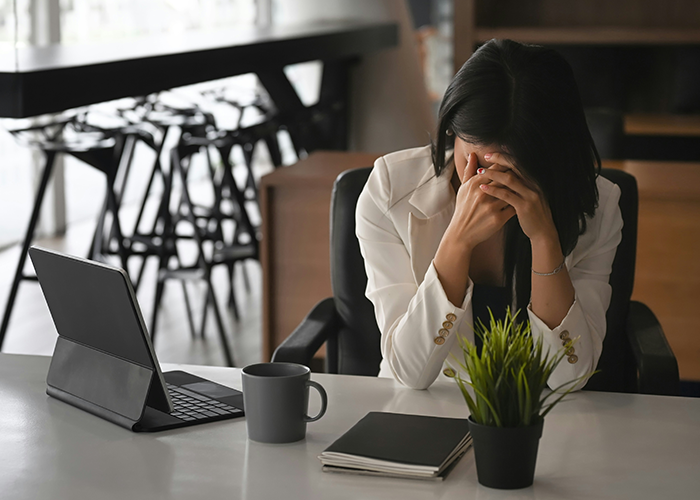 Stressed businesswoman at desk with tablet and coffee, reacting to server down during business hours with malicious compliance. Stressed businesswoman at desk with tablet and coffee, reacting to server down during business hours with malicious compliance.