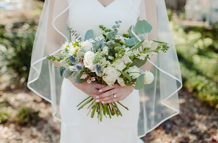 Bride in white dress holding a bouquet of flowers, symbolizing moments when school gossip turned out as facts.